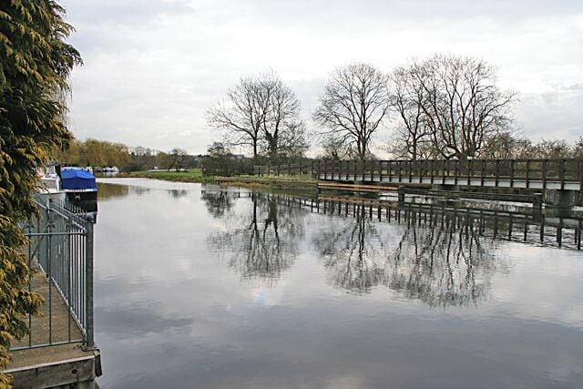 Grand Union Canal/River Soar Taken from Welland Road. Many of the houses on the landward side of the road have moorings here. The canal joins the river at this point, the footbridge over the wide weir is on the right.
