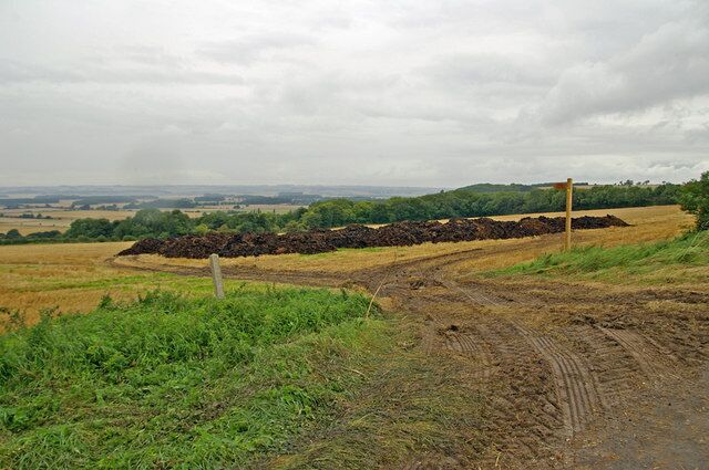 Muck ready for spreading near Bonby Photo taken on Middlegate on a rather grey afternoon. The concrete post in the foreground is a road boundary marker.