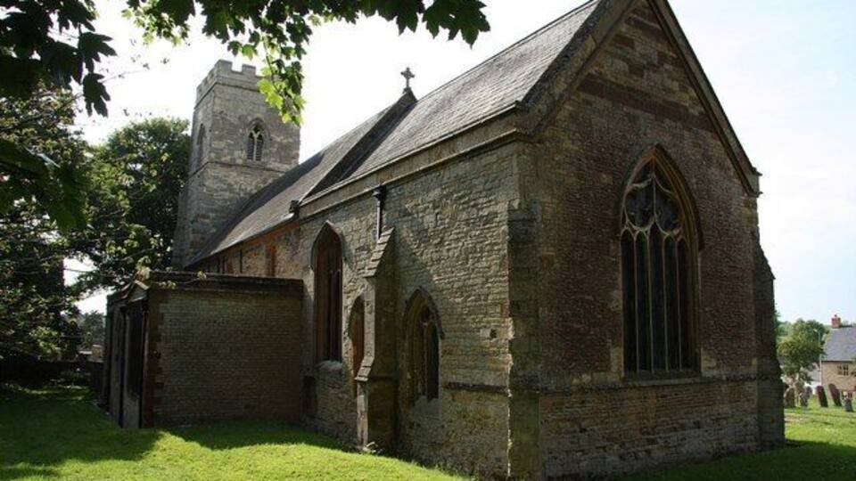 A stone church with a bell tower and arched windows.