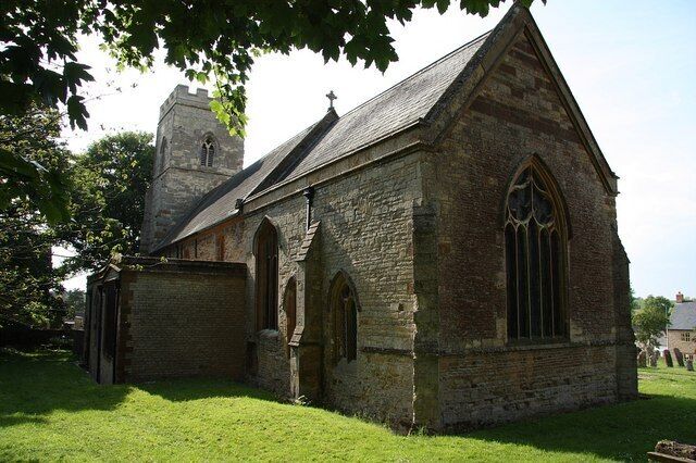A stone church with a bell tower and arched windows.