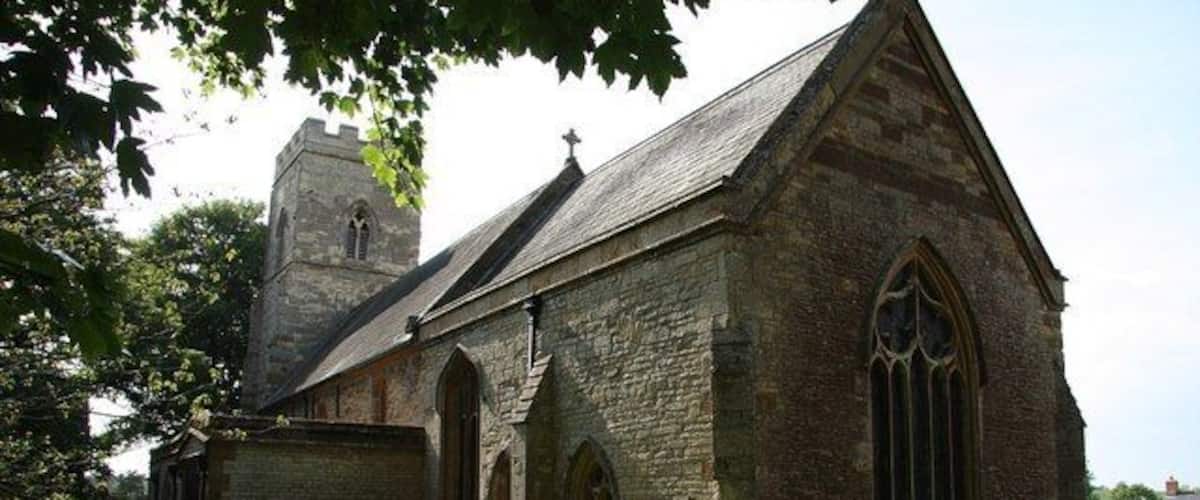 A stone church with a bell tower and arched windows.