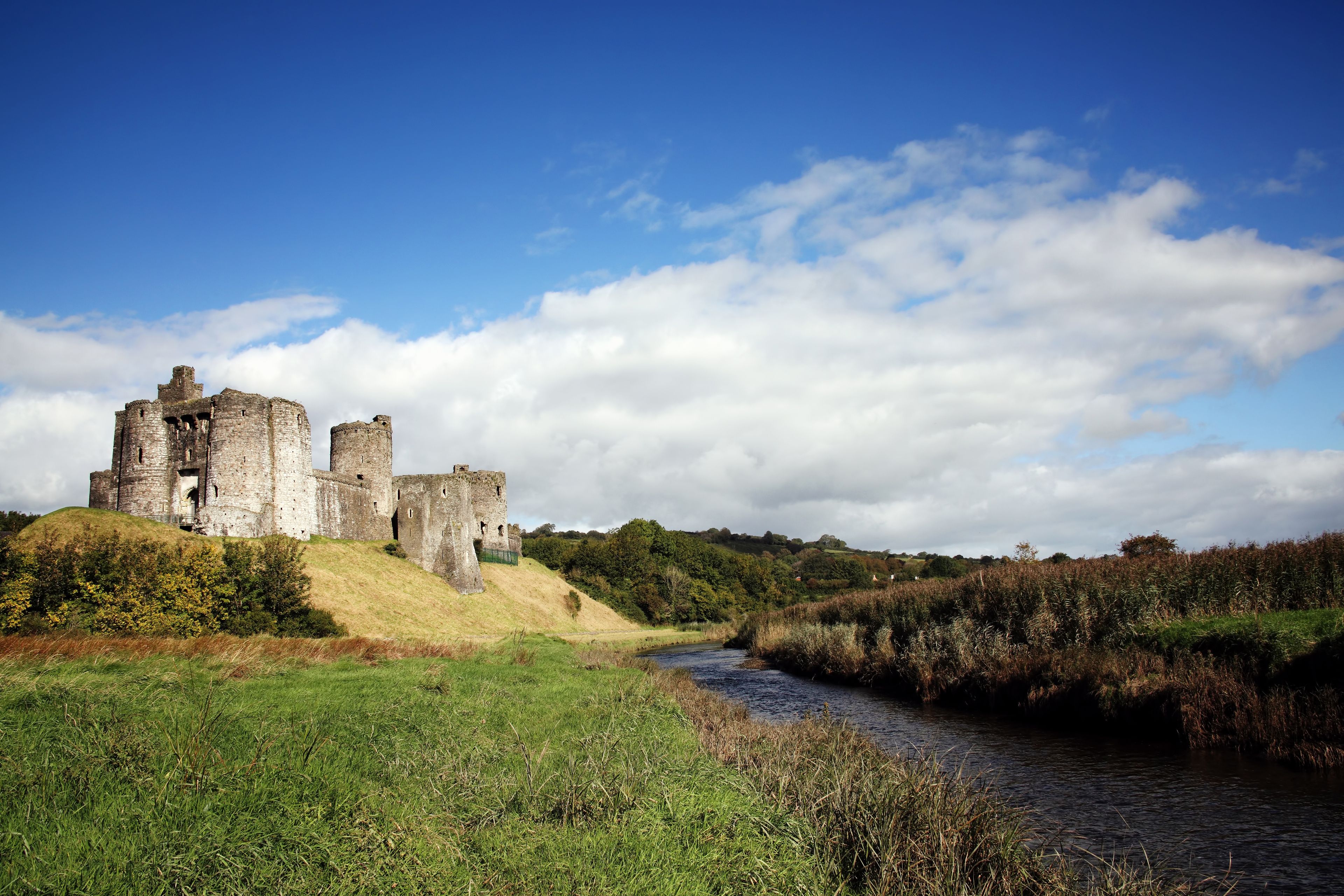A historic castle on a hill overlooking a river.