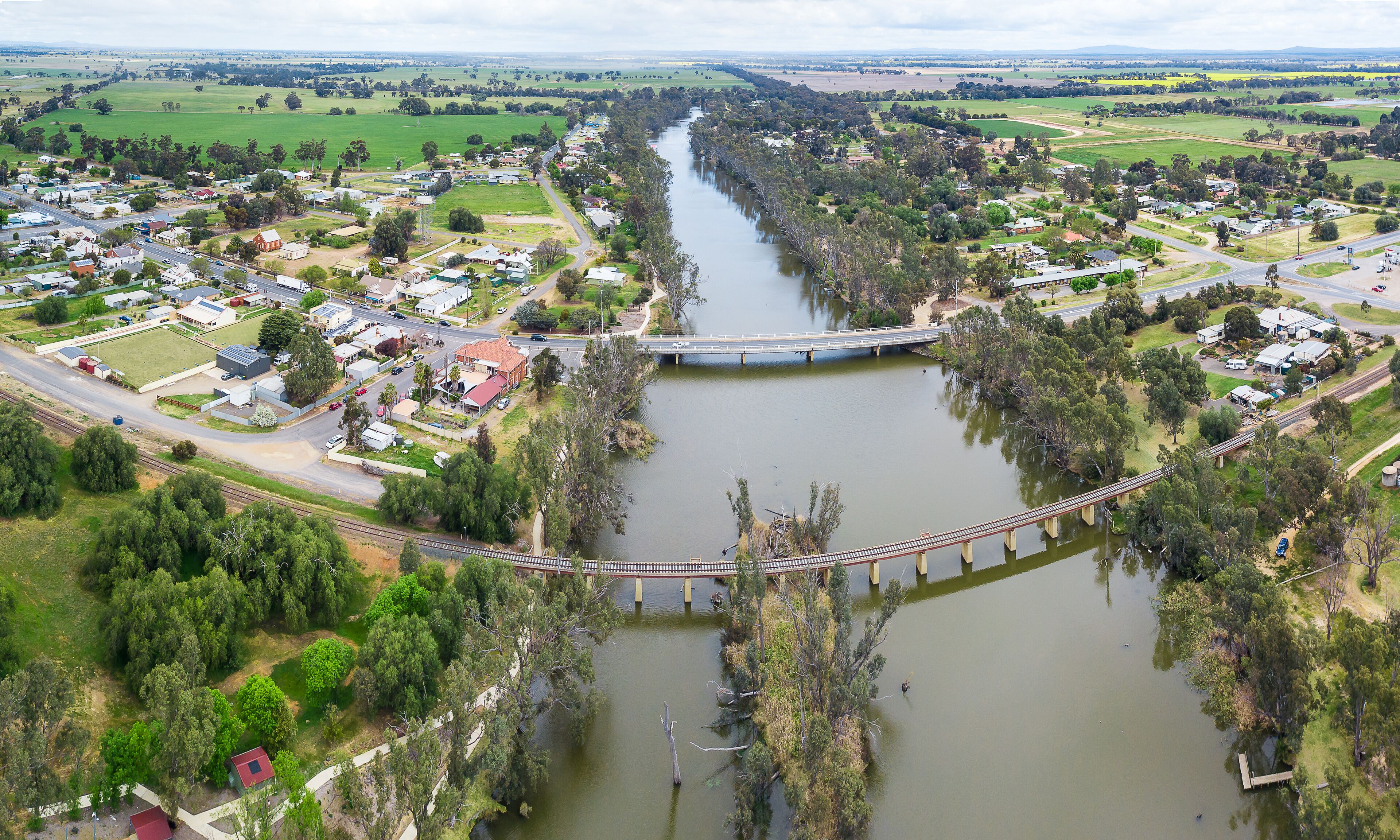 A river flowing through a town with a bridge crossing it.