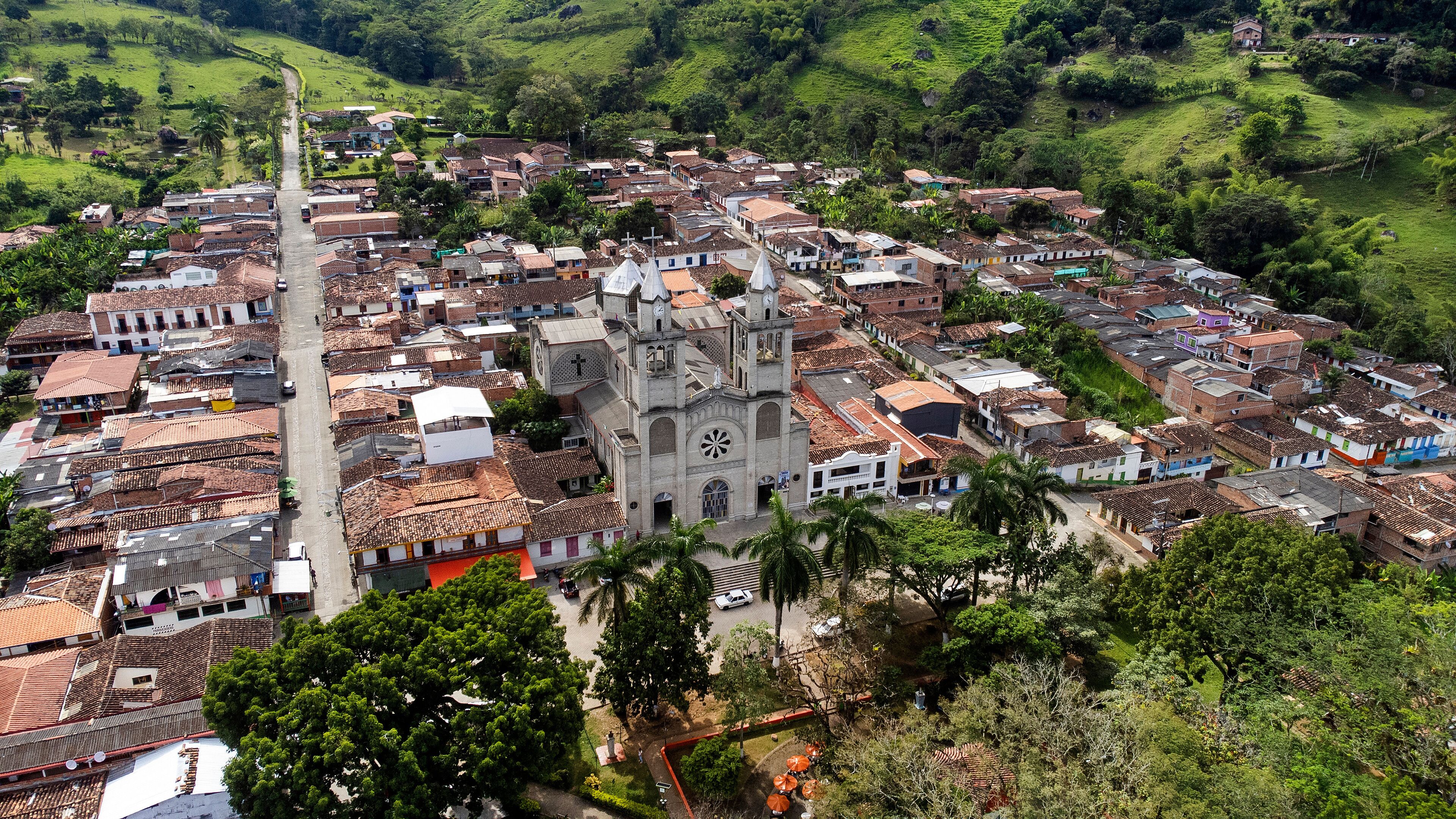 A town with a prominent church, terraced hills, and a mix of residential buildings.