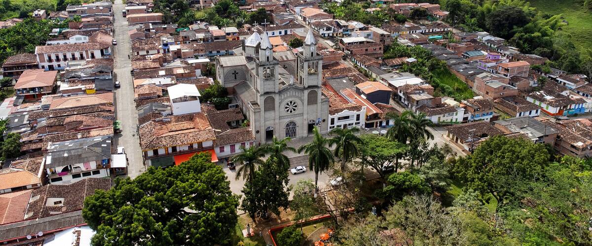 A town with a prominent church, terraced hills, and a mix of residential buildings.