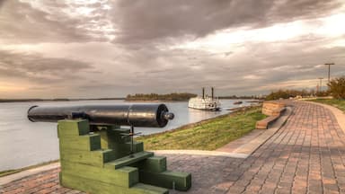 Mississippi River Walk at New Madrid. A magnificent view of the Mississippi river from atop of the levee. A steamboat is docked down river. .