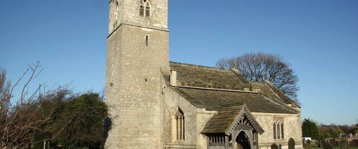 A church with a tall tower and a small entrance.