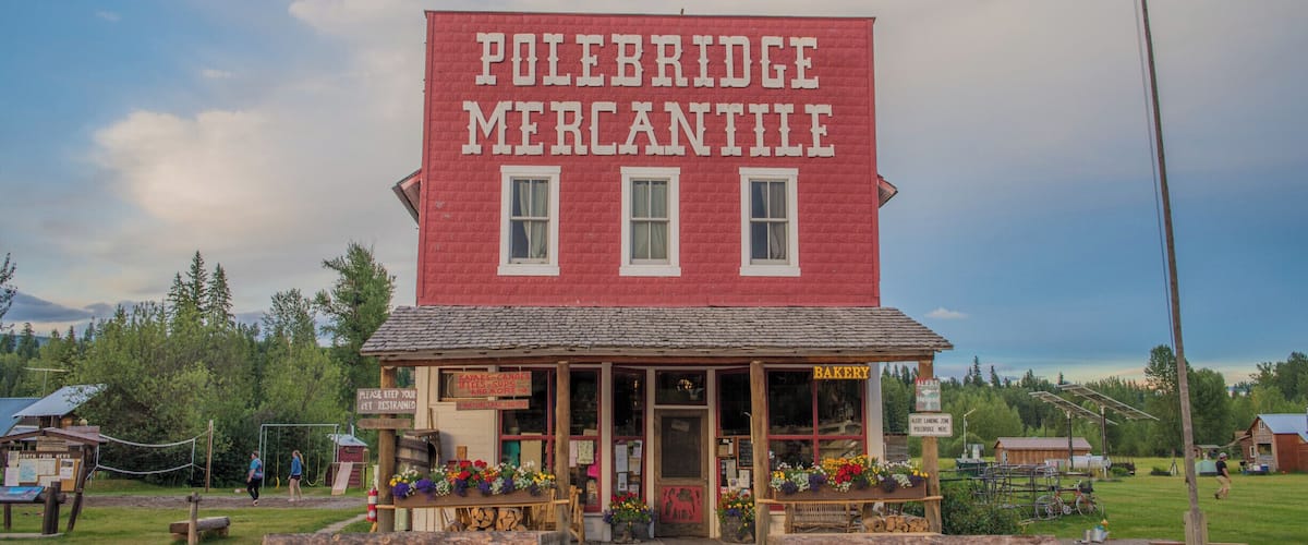 A red building with a sign reading "Polebridge Mercantile" and an American flag.