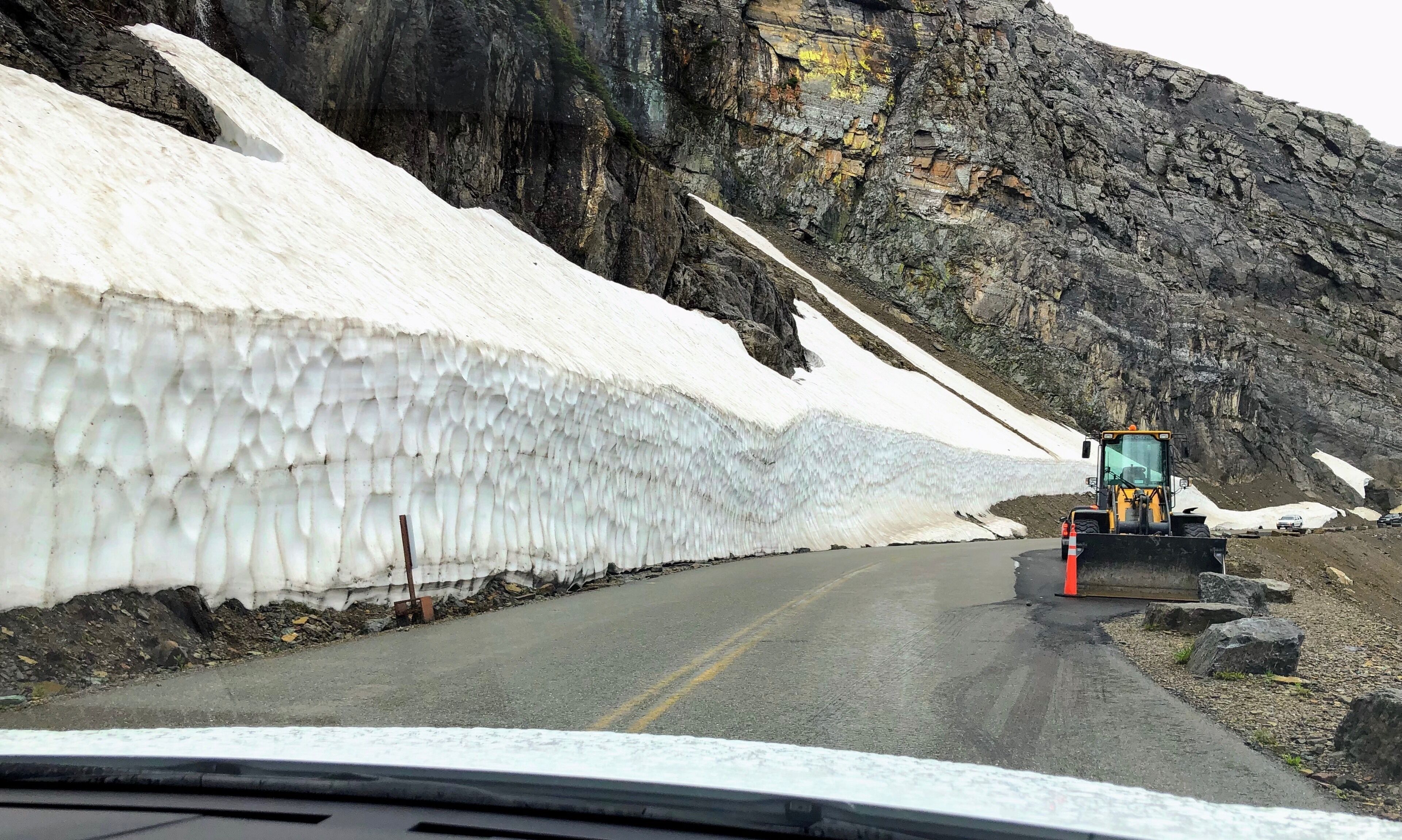 Glacier National Park at  Logan Pass along the Going to the Sun Road heading north after the Big Drift. Logan Pass, at 6,646’ is the highest point, is barely two lanes in the summer– not to mention the 2,000’ drop on the south side of the road.  The Big Drift is a site east of Logan Pass where snow depths reach between 40 and 80 feet.The teams started clearing snow on April 1, using excavators to reduce the walls to a manageable level. They then used snowplows to clear the rest. That section of the Park reopened on June 22 and this pic was taken June 23, 2019.

#Trovember