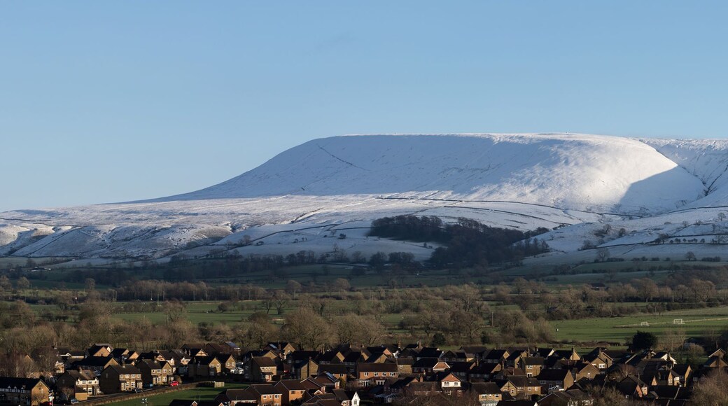 Ein schneebedeckter Berg mit einem Dorf im Vordergrund.