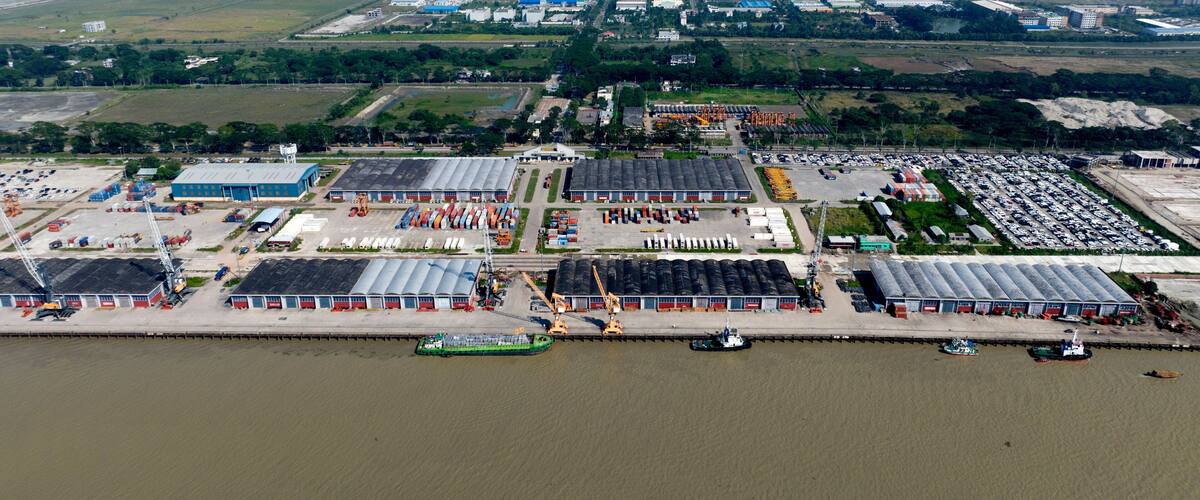 An industrial area with warehouses, a large parking lot, and a river.