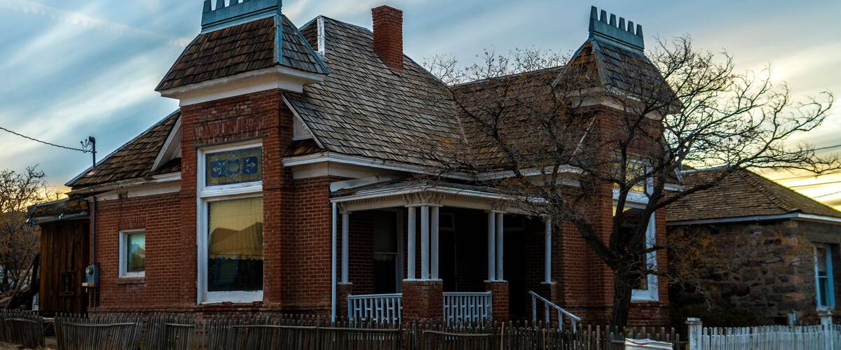 A Victorian-style building with a brick facade, a gabled roof, and decorative chimneys.
