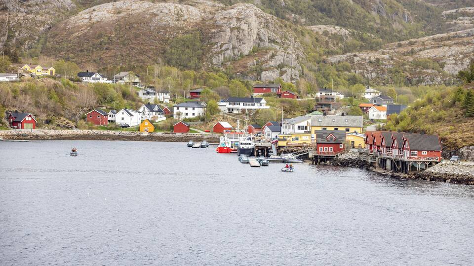 A coastal village with colorful houses and boats docked at the pier.
