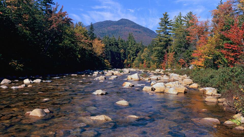 Panoramic view of an autumn waterway along the Kancamagus Highway in the White Mountain National Forest, New Hampshire