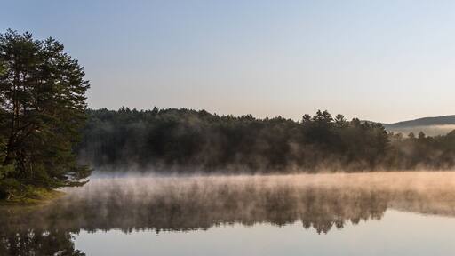 Gorgeous sunrise over pond with mountain views panorama