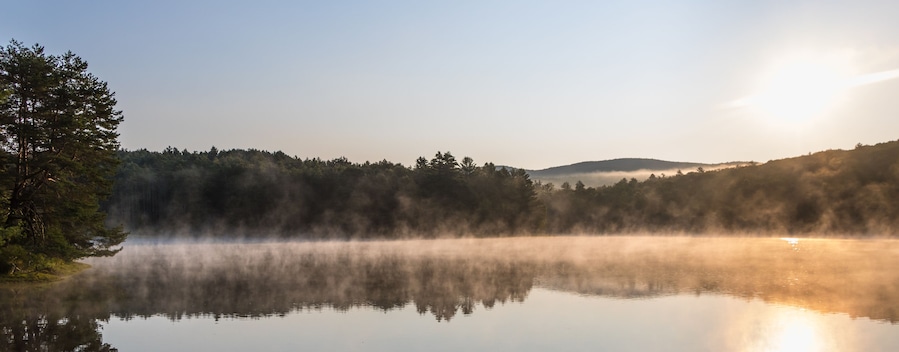 Gorgeous sunrise over pond with mountain views panorama