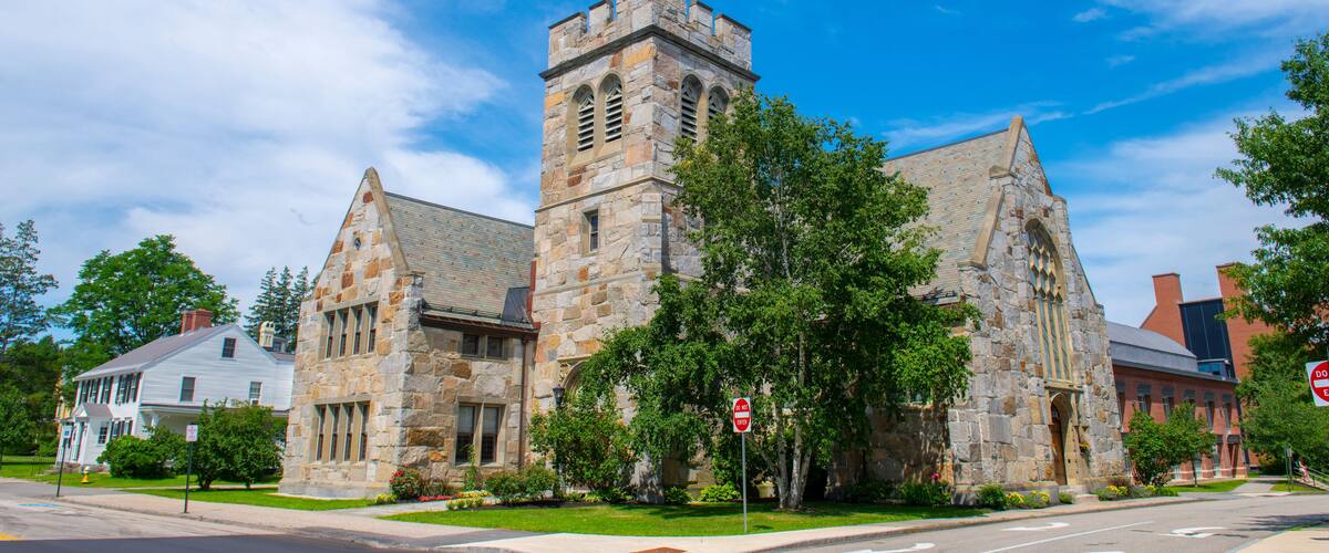 A historic stone church with a prominent tower and arched windows.