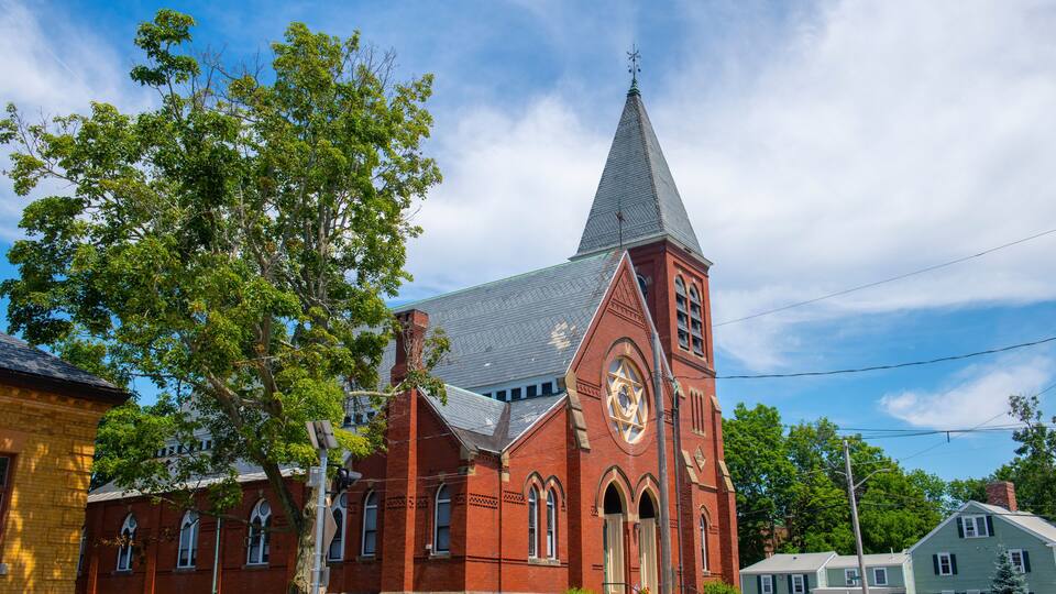 A red brick church with a steeple and a clock tower.