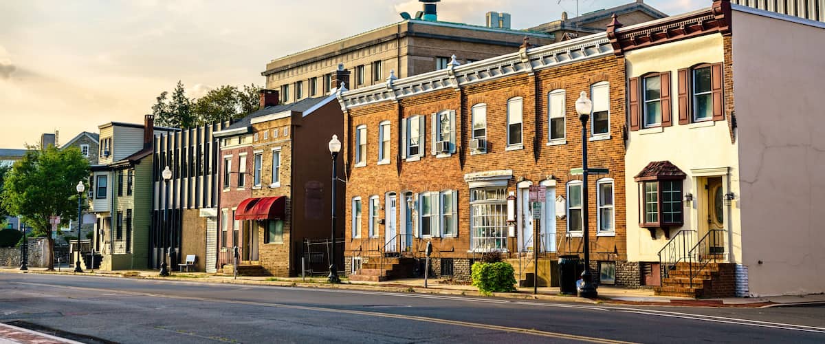 A street lined with historic brick buildings, a clear sky, and a few clouds.