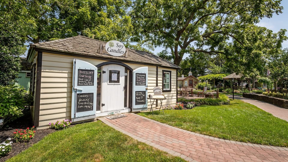 A small, quaint shop with a sign reading "Candles" and a "Buzz Off" sign.