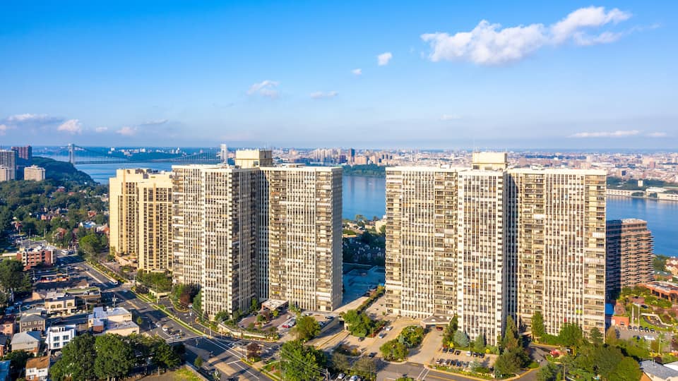 A cityscape with high-rise buildings, a river, and a bridge in the background.