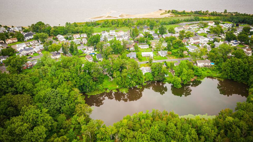 A residential area with houses, a lake, and a beach.