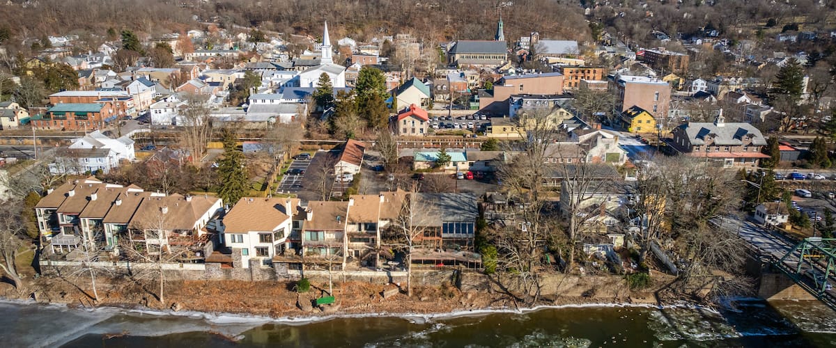 A town with a river, buildings, and a hill in the background.