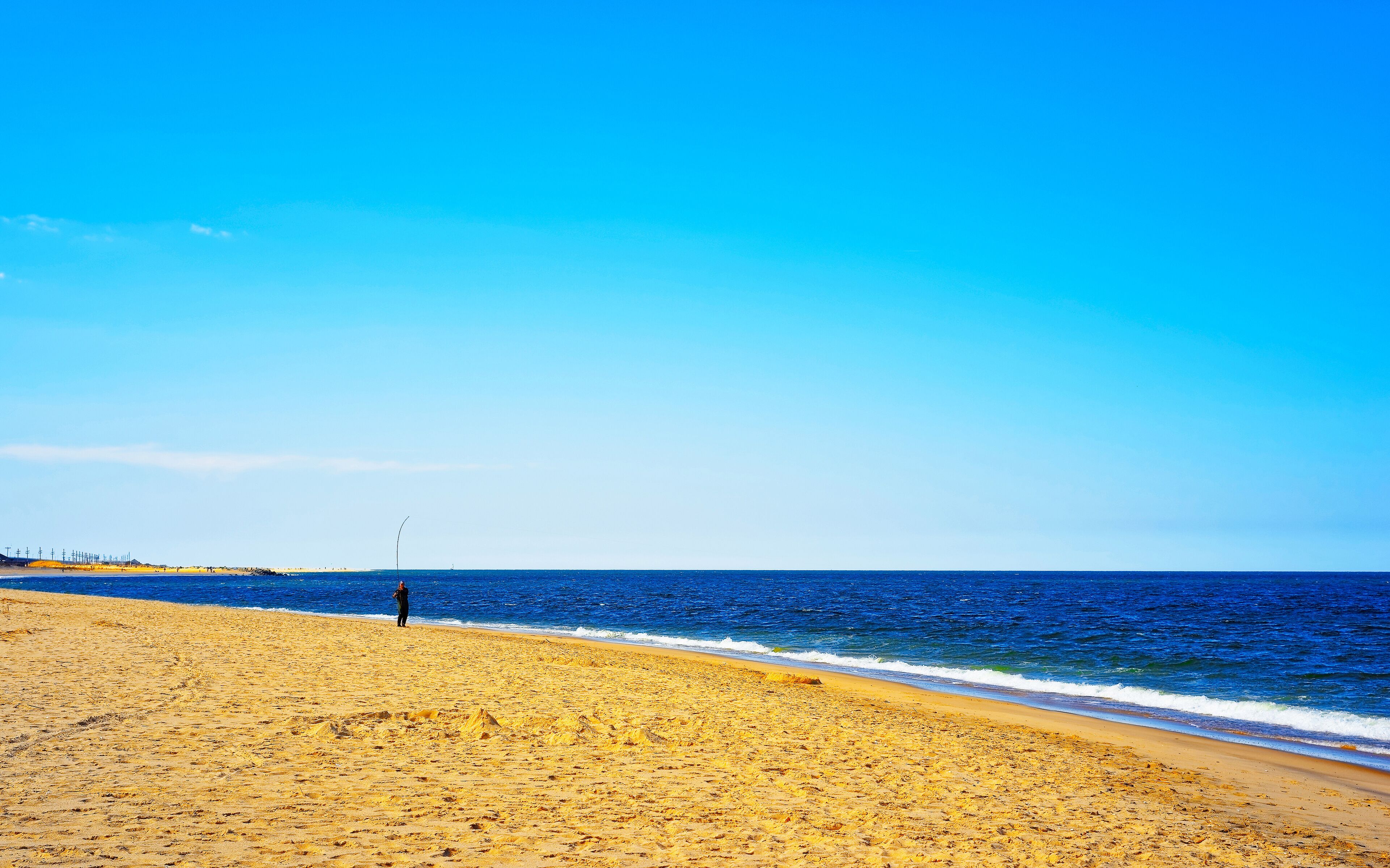 Man fishing at Atlantic Ocean shore at Sandy Hook reflex