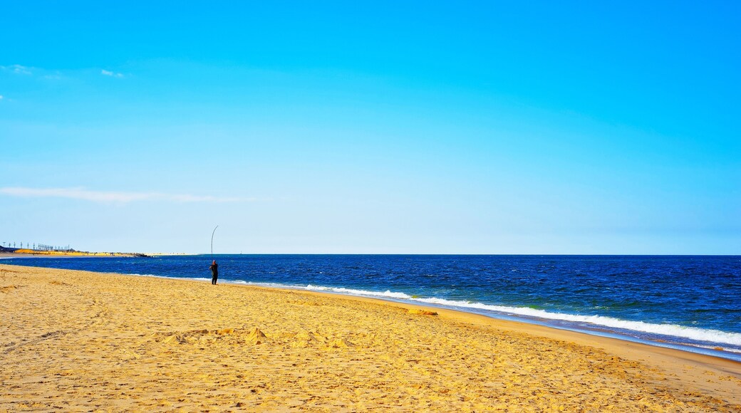Man fishing at Atlantic Ocean shore at Sandy Hook reflex
