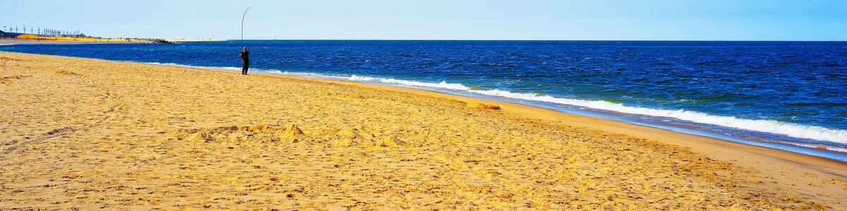 Man fishing at Atlantic Ocean shore at Sandy Hook reflex