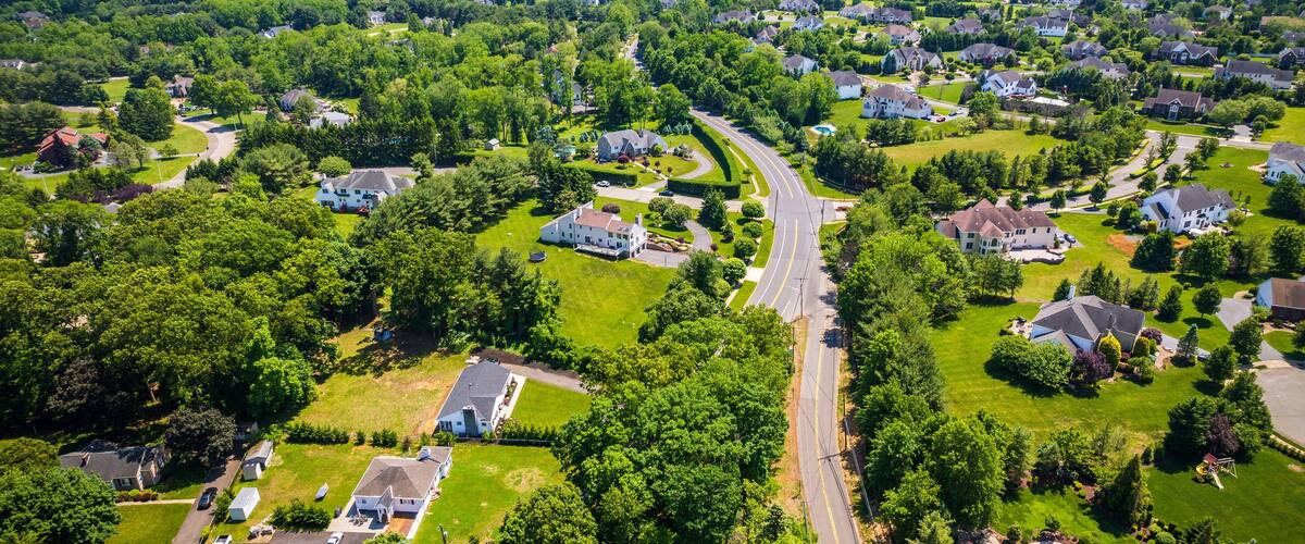 A suburban neighborhood with houses, green lawns, and a winding road.