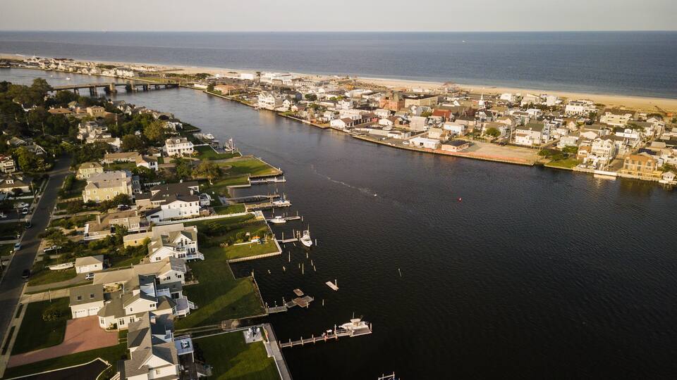 A coastal town with a river, houses, and a bridge.