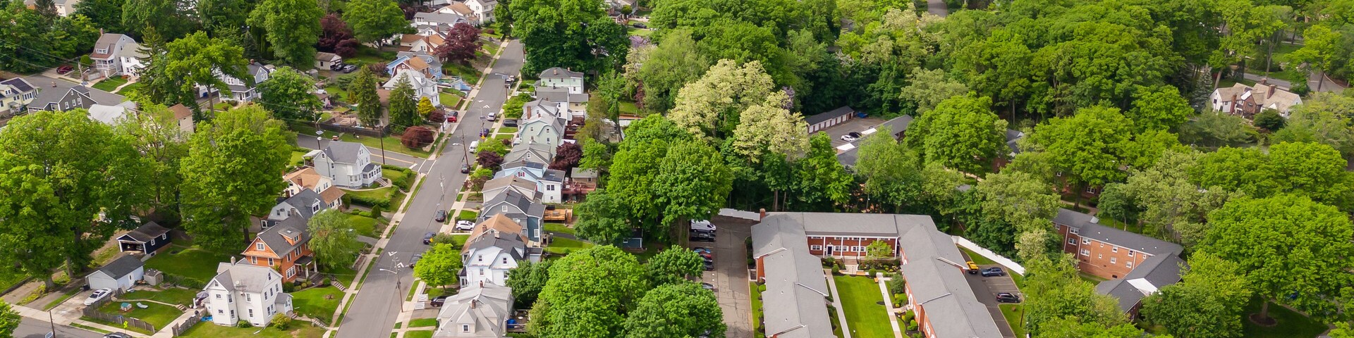 Vista aérea de una zona residencial con casas, calles y vegetación circundante.