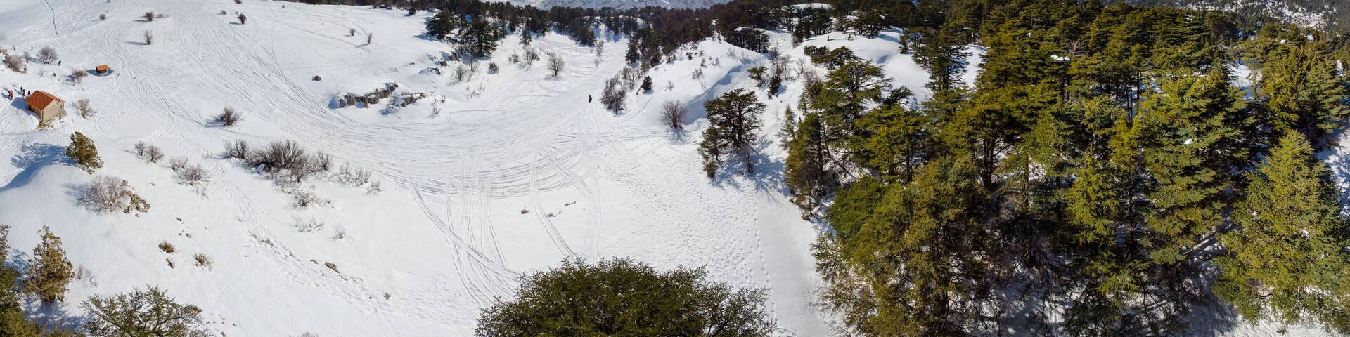 Aerial panorama of Mount Lebanon and cedar forest in winter. Drone view of Mount Lebanon mountain range, with old cedar tree forest, snow covered landscape in winter, Lebanon, Middle East