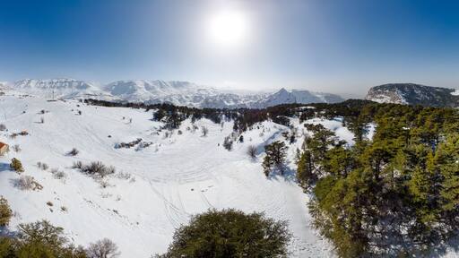 Aerial panorama of Mount Lebanon and cedar forest in winter. Drone view of Mount Lebanon mountain range, with old cedar tree forest, snow covered landscape in winter, Lebanon, Middle East
