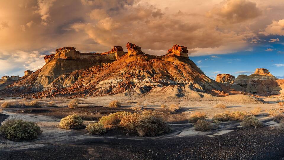 A rugged desert landscape with prominent rock formations and sparse vegetation.