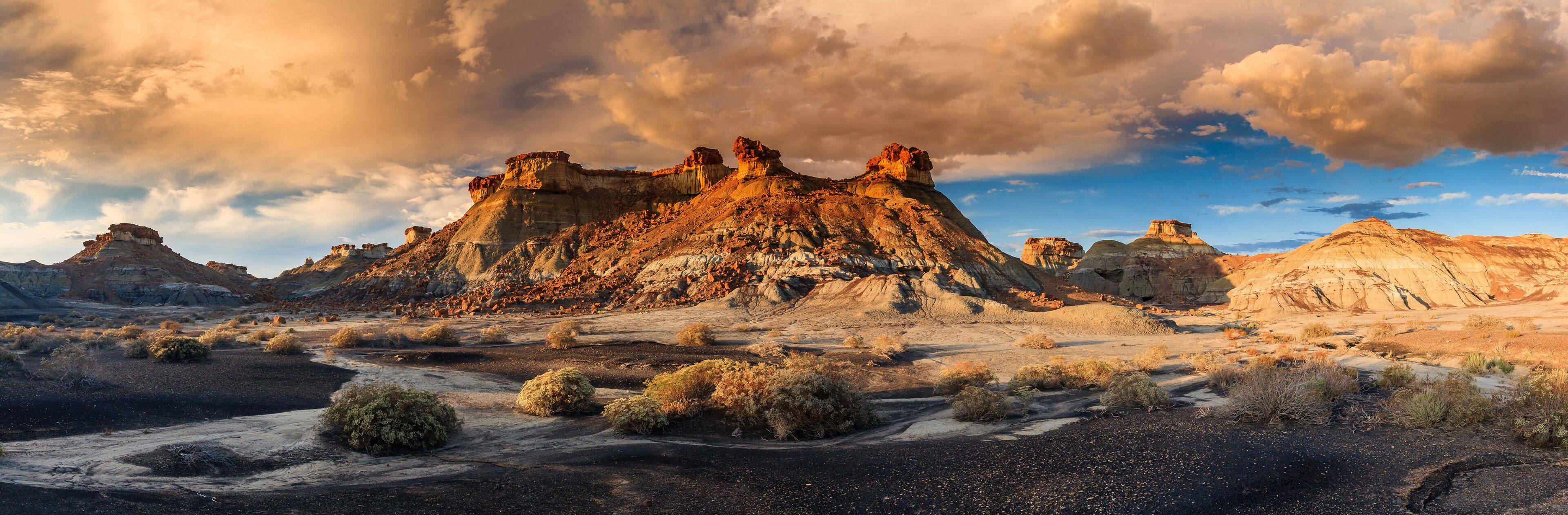 A rugged desert landscape with prominent rock formations and sparse vegetation.