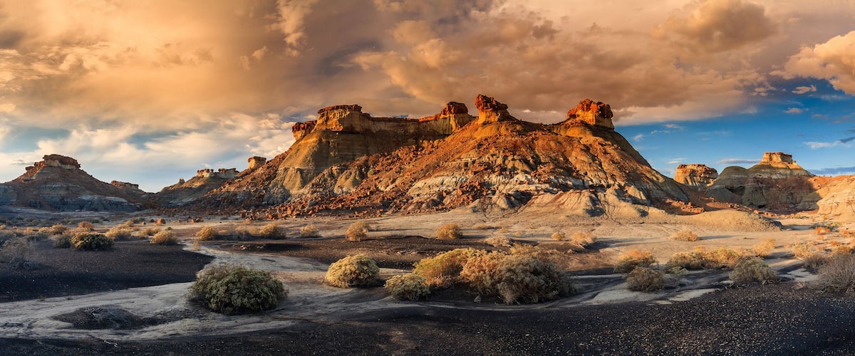 A rugged desert landscape with prominent rock formations and sparse vegetation.