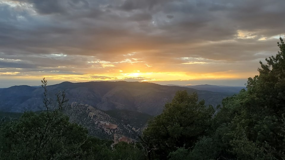 A mountainous landscape with a sunset.