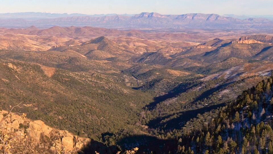 A mountainous landscape with rugged peaks and dense forests.