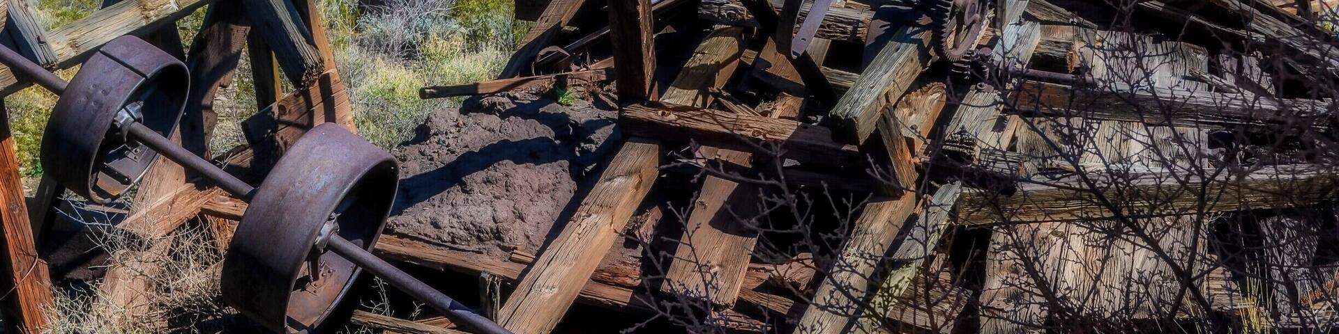 A dilapidated water wheel in a desert landscape.