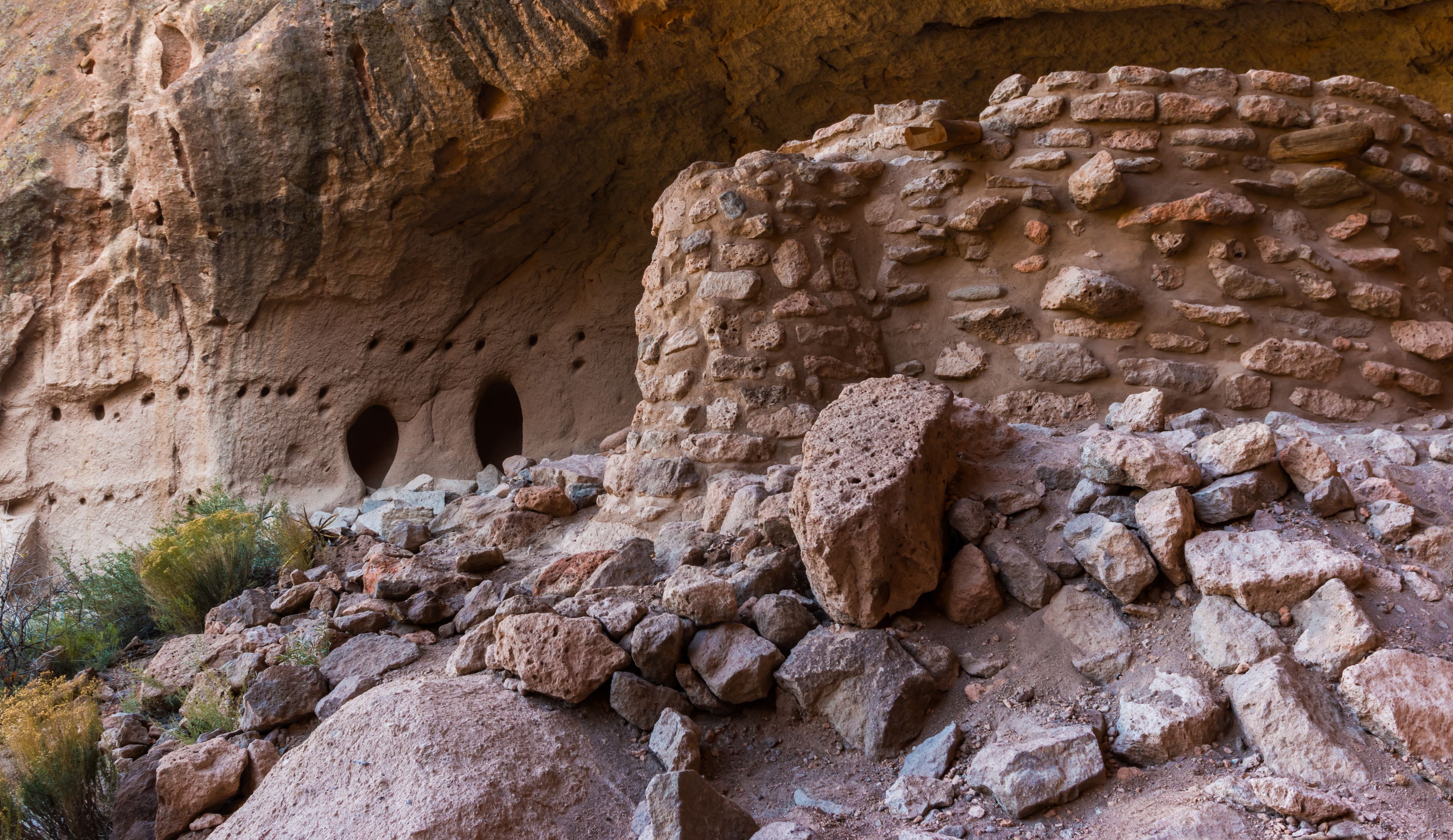 Antiguas estructuras rocosas con agujeros, en un paisaje pedregoso.