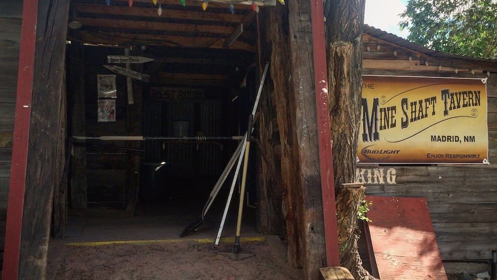 Der Eingang zum Museum der alten Kohlebergbausiedlung in Madrid, NM, mit einem Schild für das Minenschacht-Wirtshaus in der Nähe.