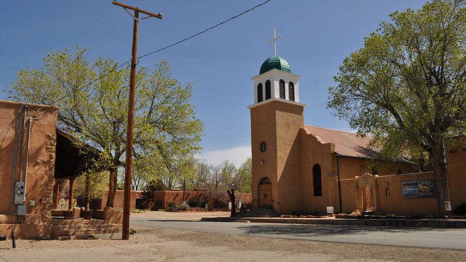 A church with a green dome and a bell tower.