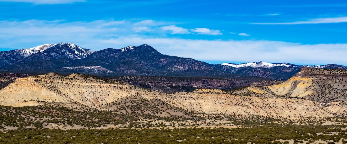 A mountainous landscape with sparse vegetation and a clear blue sky.