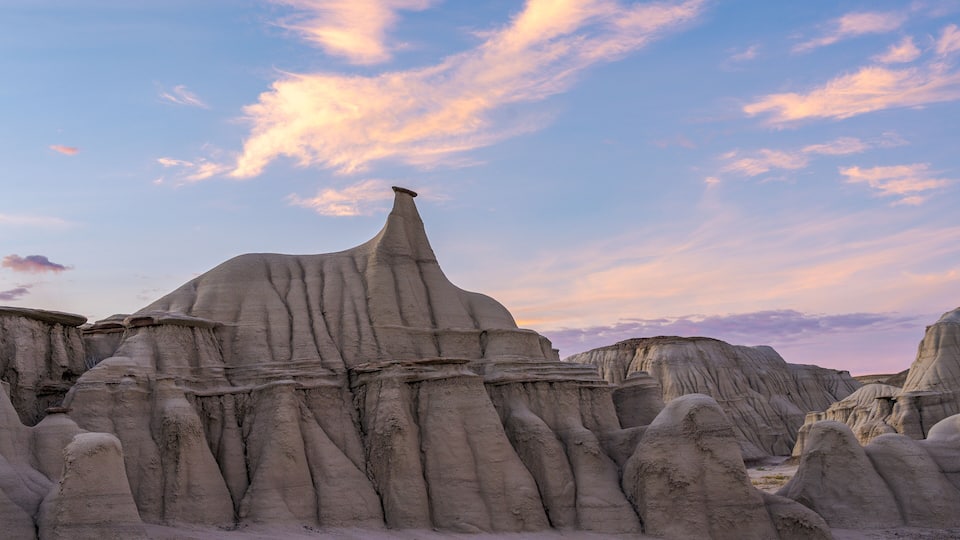 A landscape of eroded rock formations with a clear sky.