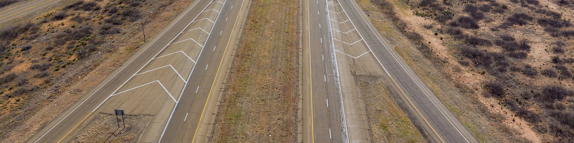 Aerial view of long road through desert landscape towards near San Jon New Mexico USA
