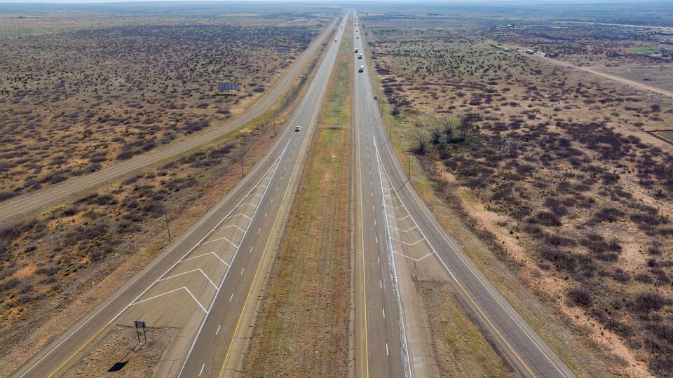 A highway with multiple lanes extending through a desert landscape.