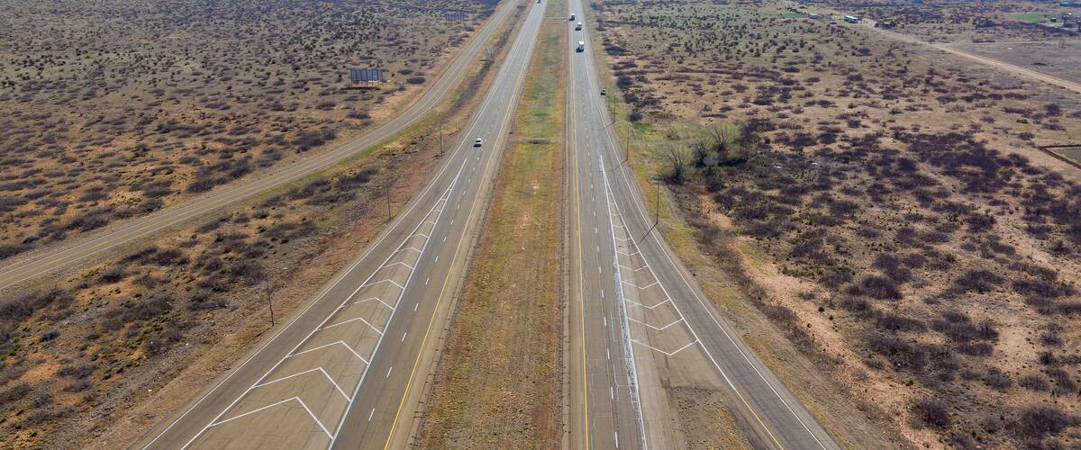 A highway with multiple lanes extending through a desert landscape.