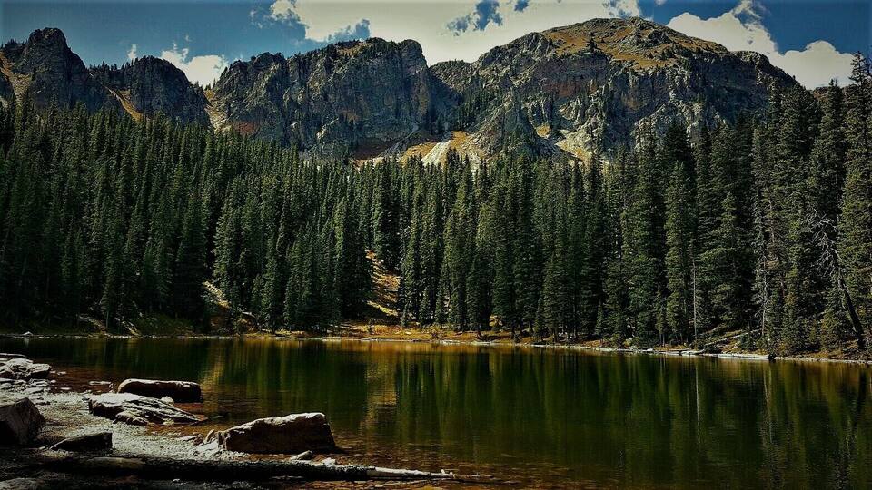 A mountain range with a lake in the foreground.